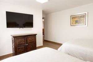 a bedroom with a bed and a tv on the wall at Pasaje Las Rosas in Cuernavaca