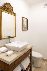 a bathroom with a white sink and a toilet at Pasaje Las Rosas in Cuernavaca +13 photos