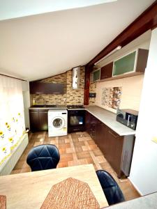 a kitchen with a washer and dryer in it at La Mansardă in Câmpulung