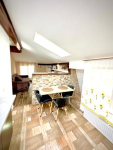 a dining room with a table and chairs and a brick wall at La Mansardă in Câmpulung +6 photos