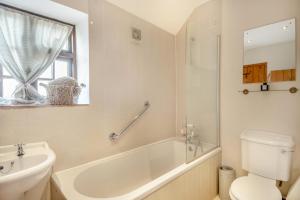 a bathroom with a tub and a toilet and a sink at 2 Bed in Grimston oc-1622 in Grimston +23 photos