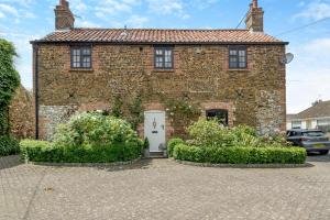 a brick house with a white door and some bushes at 2 Bed in Grimston oc-1622 in Grimston