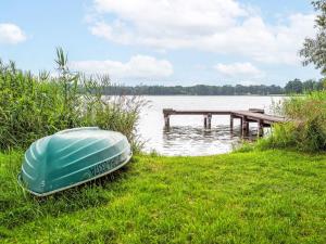 a green boat sitting on the grass next to a dock at Apartment Głęboczek 21 by Interhome in Głęboczek