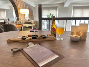 a table with a tray of food and glasses of wine at Grand Canal Boutique Hotel Delft in Delft