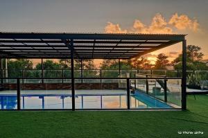 a view of a swimming pool with a pavilion at וילת היוצר in Ya‘ara