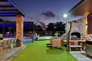 a patio with a grill and a table and chairs at וילת היוצר in Ya‘ara