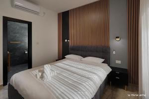 a bedroom with a large white bed in a room at וילת היוצר in Ya‘ara +16 photos