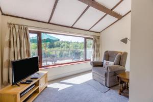 a living room with a flat screen tv and a chair at 5 Bed in Clows Top oc-m32976 in Bayton