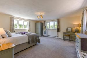 a bedroom with a bed and a desk and windows at 5 Bed in Clows Top oc-m32976 in Bayton