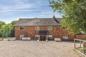 a brick building with benches in front of it at 5 Bed in Clows Top oc-m32976 in Bayton