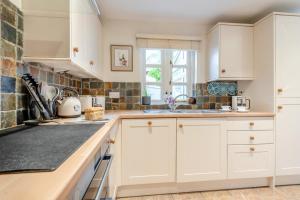 a kitchen with white cabinets and a window at 2 Bed in Weobley oc-c32945 in Weobley