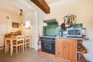 a kitchen with a stove and a table with a microwave at 2 Bed in Bacton oc-710 in Bacton