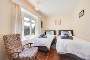 a bedroom with two beds and a chair and a window at 2 Bed in Bacton oc-710 in Bacton +27 photos