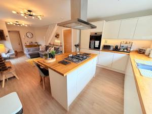 a kitchen with white cabinets and a wooden counter top at Margate Duplex with Private Terrace Air Conditioning The Duplex Margate in Margate