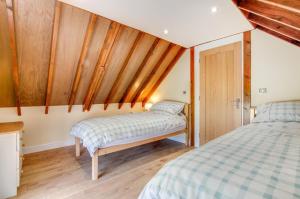 two beds in a small room with wooden walls at 3 Bed in Llanrwst oc-wag689 in Llanrwst