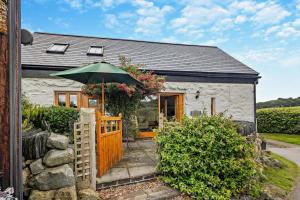 a white cottage with an umbrella in front of it at 3 Bed in Llanrwst oc-wag689 in Llanrwst