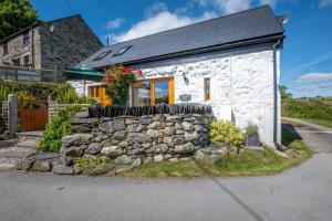 a small white cottage with a stone wall at 3 Bed in Llanrwst oc-wag689 in Llanrwst +15 photos