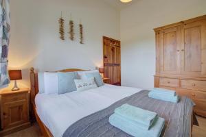 a bedroom with a white bed with blue towels on it at 2 Bed in Roughton oc-1626 in Roughton +20 photos