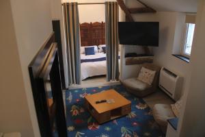 ein kleines Wohnzimmer mit einem Bett und einem Fernseher in der Unterkunft Villa Marguerite in Castelnau-Rivière-Basse