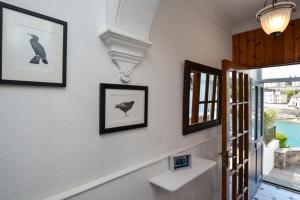 a hallway with two pictures on the wall and a bird picture at 3 Bed in Porthleven oc-7bayvi in Porthleven
