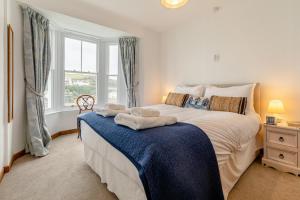 a bedroom with a large bed with towels on it at 3 Bed in Porthleven oc-7bayvi in Porthleven +11 photos