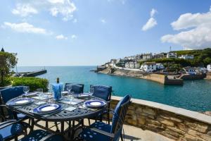 a table with chairs and a view of the ocean at 3 Bed in Porthleven oc-7bayvi in Porthleven