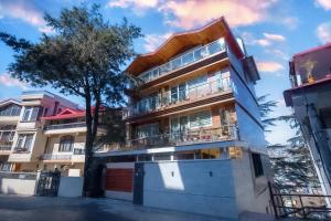 an apartment building with a tree in front of it at Samar Villa BnB in Shimla