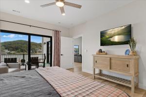 a bedroom with a bed and a ceiling fan at Modern Lakefront Escape | The Twelve in Camdenton