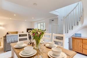 a dining room with a table with a vase of flowers at 3 Bed in Fowey oc-1cobbs in Fowey