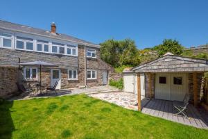 a stone house with a deck and a patio at 3 Bed in Fowey oc-1cobbs in Fowey