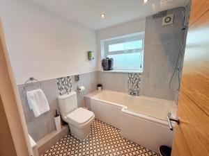 a bathroom with a tub and a toilet and a sink at Margate Duplex with Private Terrace Air Conditioning The Duplex Margate in Margate +20 photos