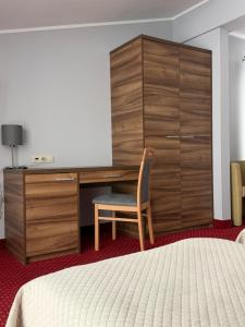 a bedroom with a dresser and a desk and a chair at Hotel Luzino in Luzino +35 photos