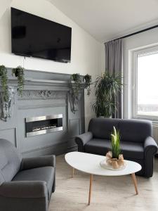 a living room with two couches and a coffee table at Hotel Luzino in Luzino