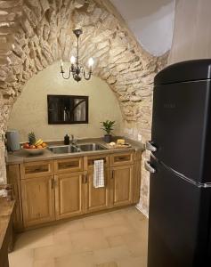 a kitchen with a sink and a black refrigerator at לאה- וילה בוטנית LEAH- botanical villa in Safed
