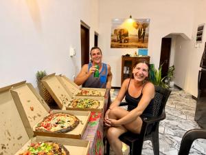 two people sitting in front of boxes of pizza at Midigama Lucky Villa in Midigama East
