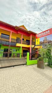 a colorful building with a fence in front of it at Pousada Fielder e Anacleto in Penha