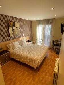 a bedroom with a large bed and a wooden floor at Hotel Les Truites Adults only in Pas de la Casa