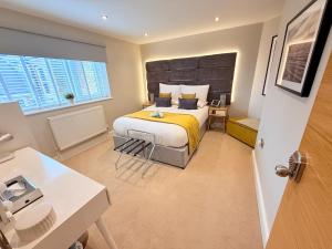a bedroom with a large bed with a yellow blanket at Margate Duplex with Private Terrace Air Conditioning The Duplex Margate in Margate