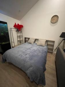a bedroom with a bed and a clock on the wall at Un cocoon spacieux in Les Essarts-le-Roi +3 photos