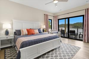 a bedroom with a large bed and a balcony at Modern Lakefront Escape | The Twelve in Camdenton +59 photos