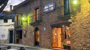 a building with a sign on the side of it at Hotel Rural La Posada de Lía in Berzocana