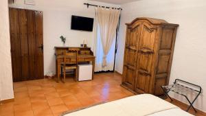 a bedroom with a desk and a wooden cabinet at Hotel Rural La Posada de Lía in Berzocana +37 photos