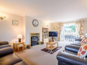 a living room with couches and a clock on the wall at 4 Bed in Bakewell oc-pk911 in Bakewell