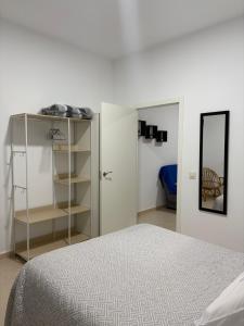 a white bedroom with a bed and a mirror at Casa 22 in Plasencia +20 photos