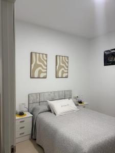 a bedroom with a bed and three pictures on the wall at Casa 22 in Plasencia