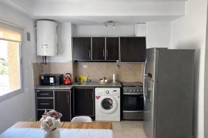 a kitchen with a refrigerator and a washing machine at Departamento Liban in San Juan