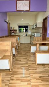 a dining room with wooden tables and a kitchen at Pousada Fielder e Anacleto in Penha
