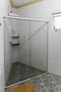 a shower with a glass door in a bathroom at Paraiso Mantiqueira in Paraisópolis