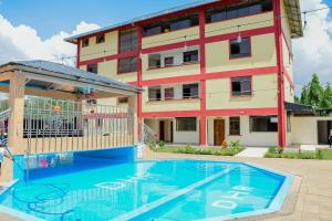 a building with a swimming pool in front of a building at Divine Homes Resort Kisumu in Kisumu