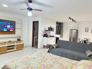 a living room with a blue couch and a kitchen at Loft Studio Central in Nova Friburgo